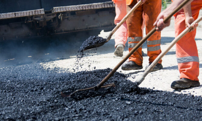 Workers shoveling asphalt
