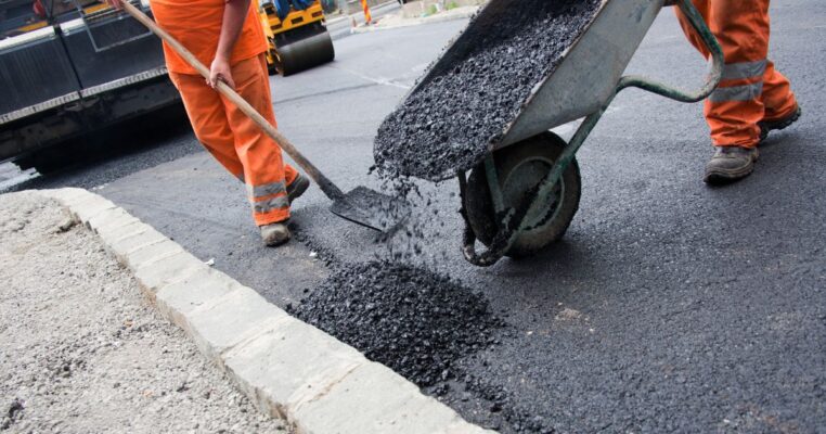 Contractors repairing asphalt