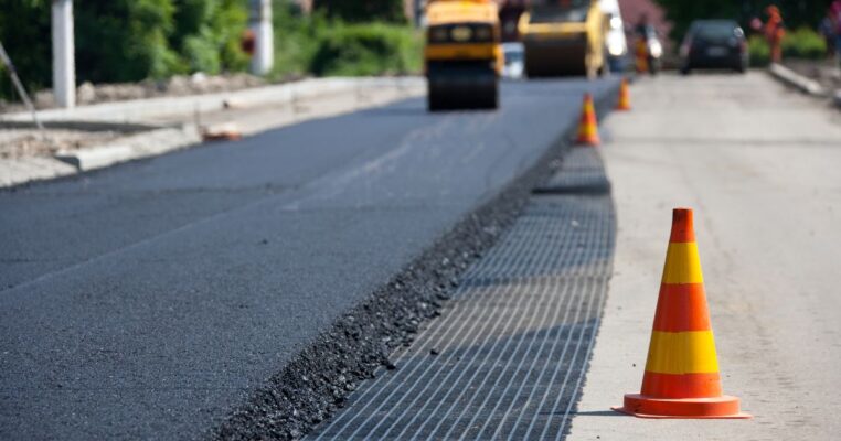 Workers installing asphalt pavement