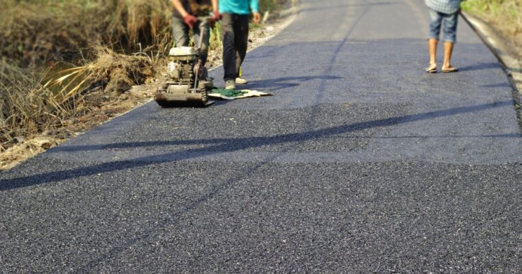 Workers maintaining asphalt pavement