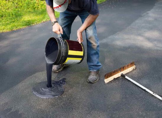 Pouring asphalt onto driveway for resealing and repair